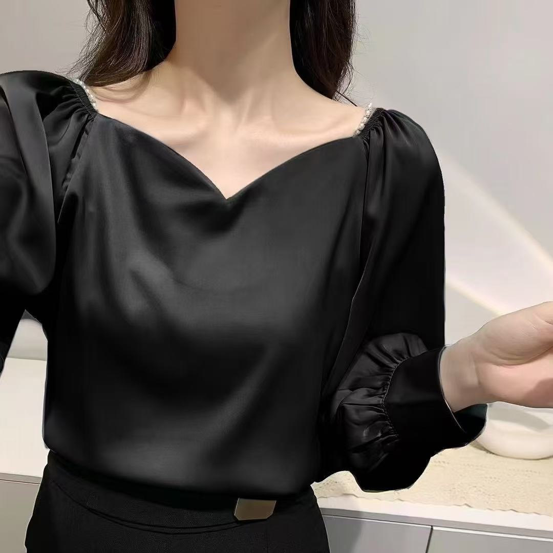 satin blouse, perfect for a vintage or office-casual Korean-inspired look, features a V-neckline with delicate pearl detailing at the shoulders and stylish gathered or ruffled long sleeves.