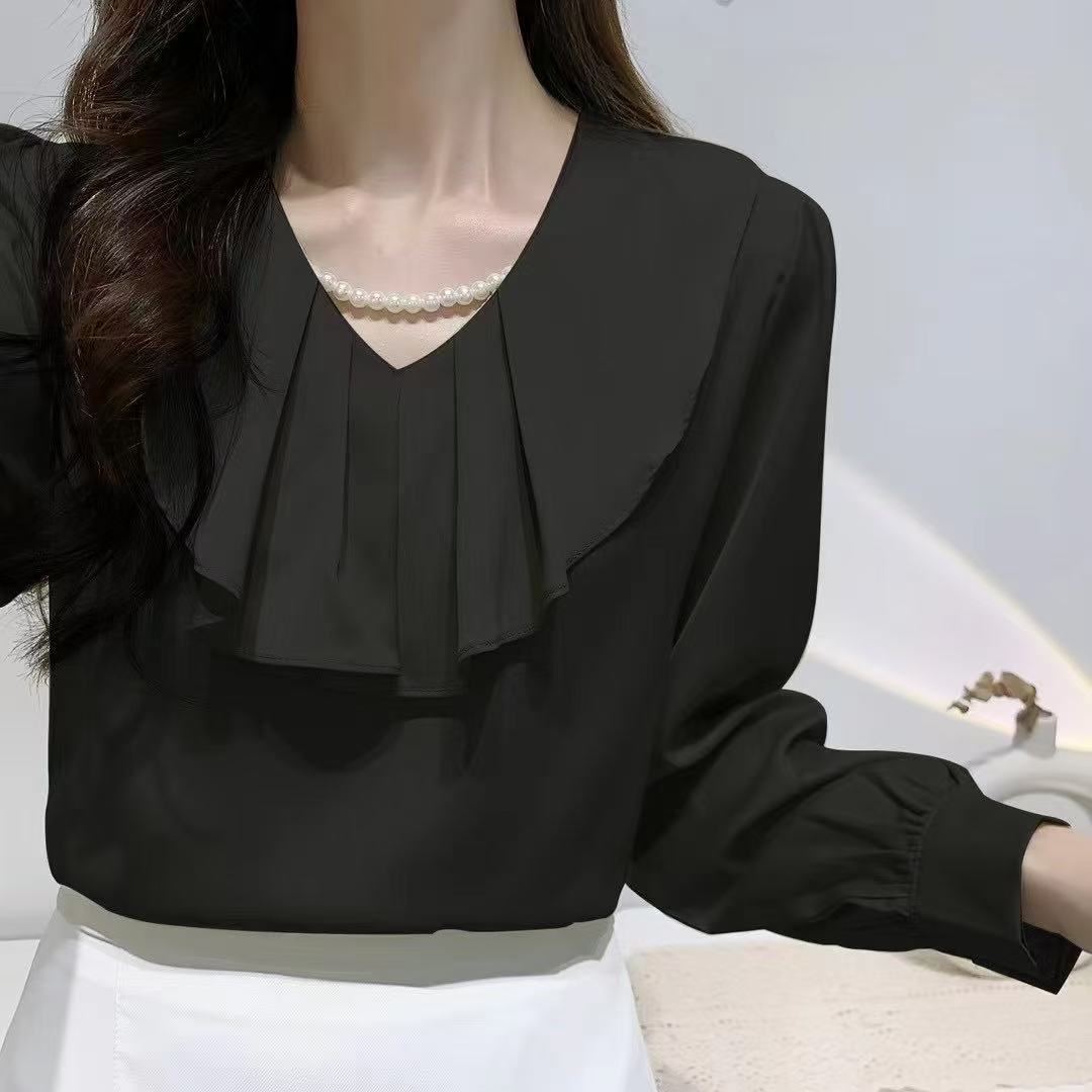 blouse with a ruffled collar and a pearl necklace.