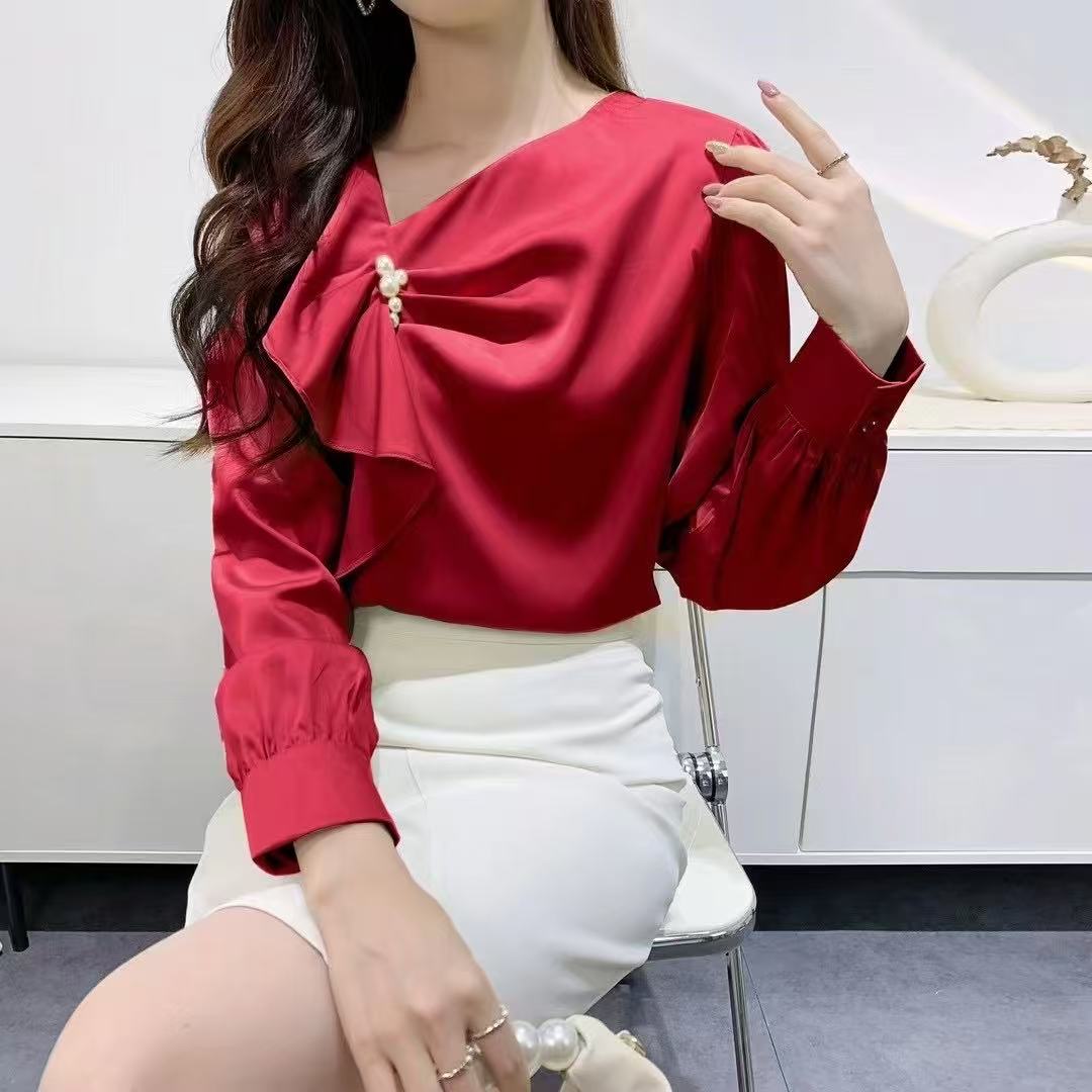 ruffled blouse with pearl.blouse has long sleeves and gathered accents on the chest, along with a pearl embellishment near the neckline.
