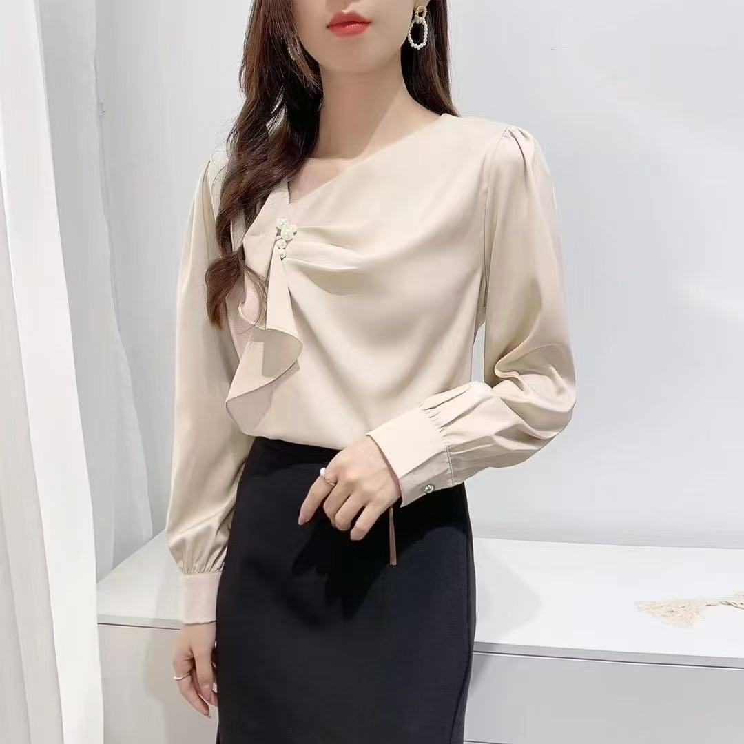 ruffled blouse with pearl.blouse has long sleeves and gathered accents on the chest, along with a pearl embellishment near the neckline.