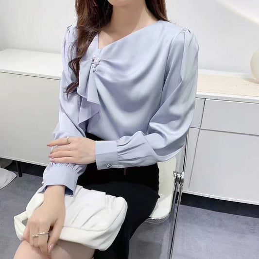 ruffled blouse with pearl.blouse has long sleeves and gathered accents on the chest, along with a pearl embellishment near the neckline.